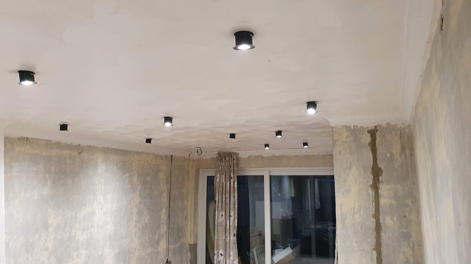 Recessed ceiling downlights mid-installation in a domestic property